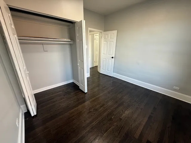 an empty room with wooden floor and door