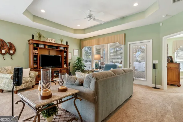 a living room with furniture a flat screen tv and a large window