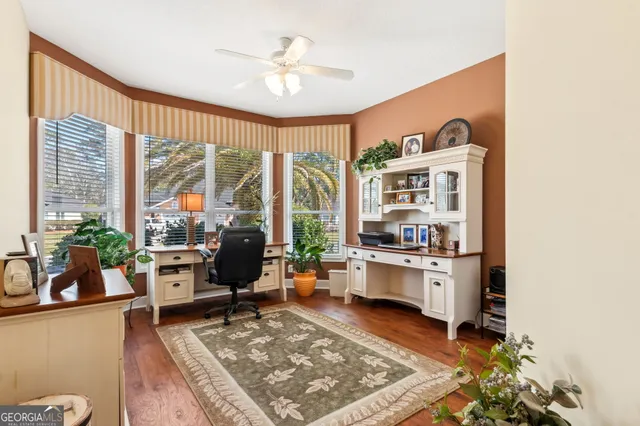 a living room with stainless steel appliances furniture a rug and a large window