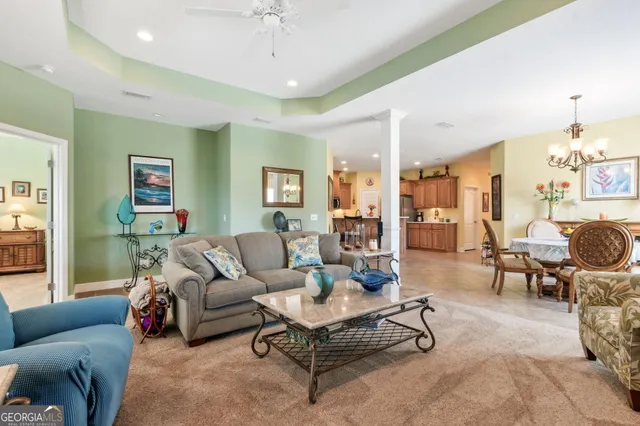 a living room with furniture and a chandelier