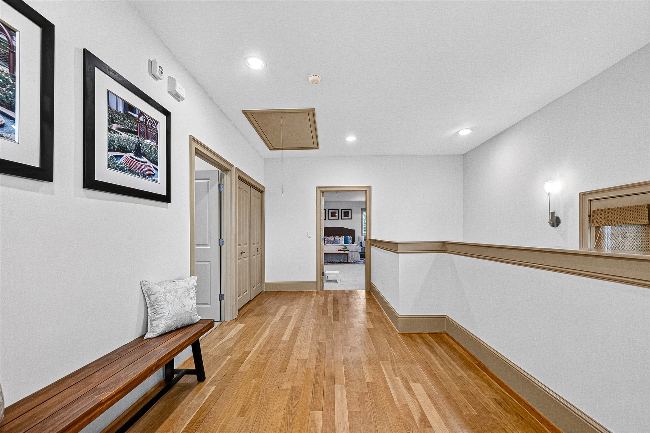 2034 Colquitt Street, Unit A Houston, TX 77098 - Photo 23 of 41 A bright 3rd floor hallway with hardwood floors features recessed lighting and wall sconces leading to 2 ensuite bedrooms. The space is classic and inviting, ideal for easy movement between rooms.