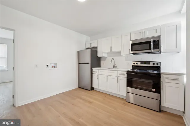 a kitchen with a refrigerator stove and white cabinets