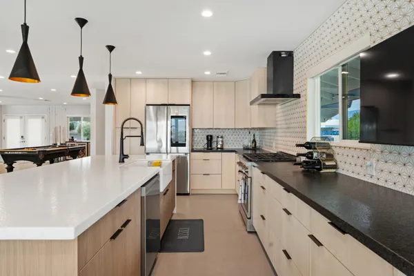 a kitchen with white cabinets a sink a stove and a wooden floors