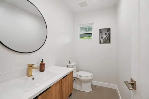 a bathroom with a sink mirror and toilet