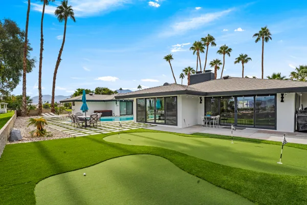 a view of a house with a backyard patio and swimming pool