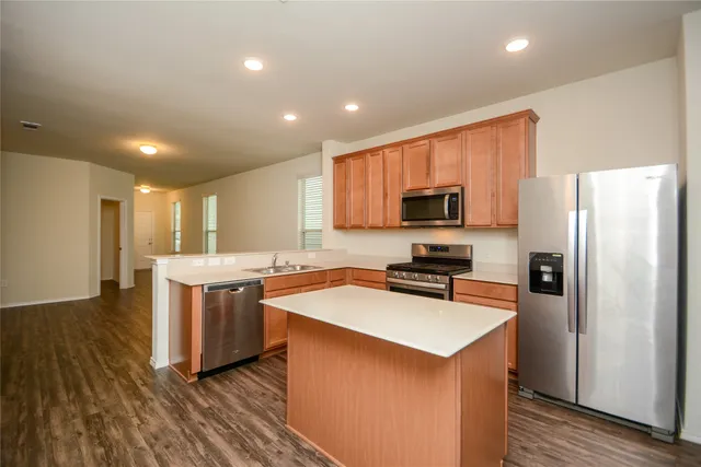 a kitchen with a stove a refrigerator and a microwave