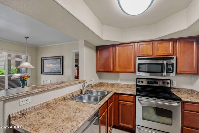 a kitchen with stainless steel appliances granite countertop a stove microwave and sink