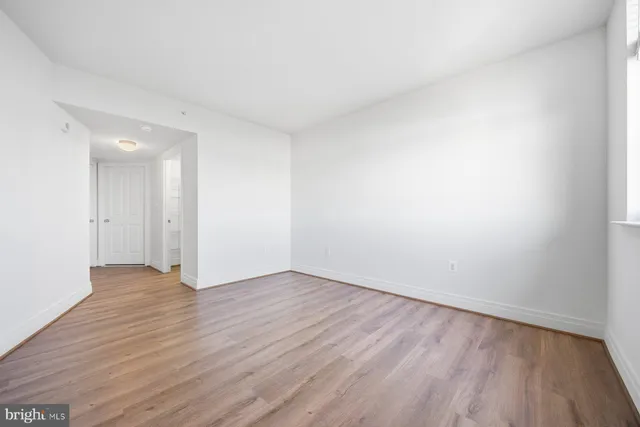 a view of an empty room with wooden floor