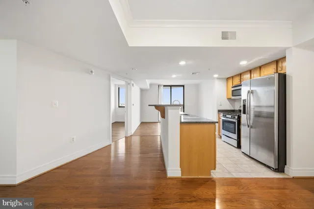 a view of a kitchen with a refrigerator a stove top oven and kitchen island