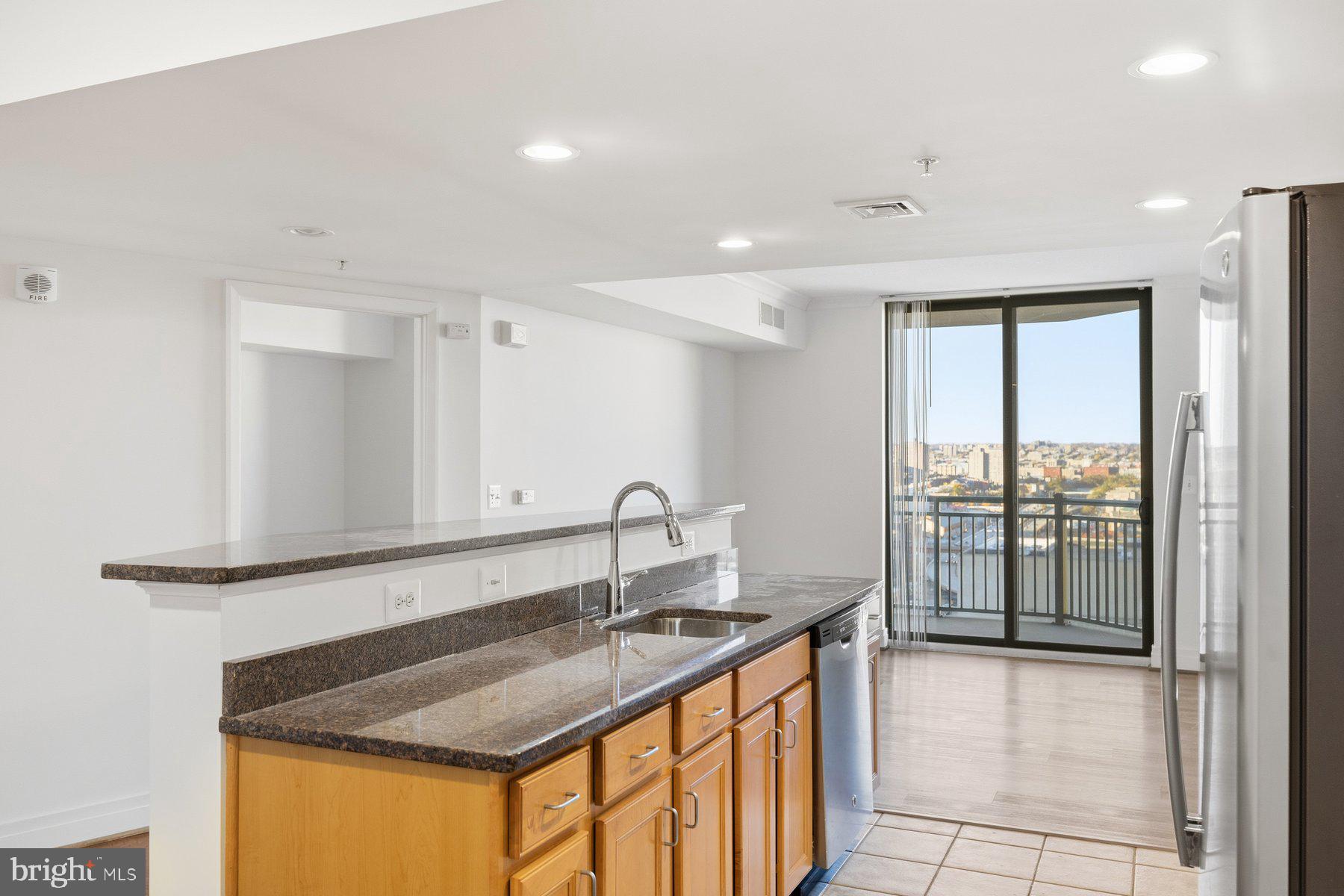 414 Water Street, Unit 2309 Baltimore, MD 21202 - Photo 24 of 36 a kitchen with granite countertop a sink and a window