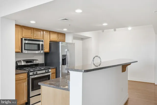 a kitchen with granite countertop a stove a sink dishwasher a refrigerator and a microwave