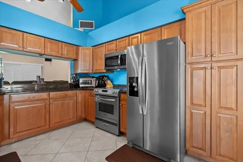 a kitchen with stainless steel appliances granite countertop a refrigerator and a stove top oven