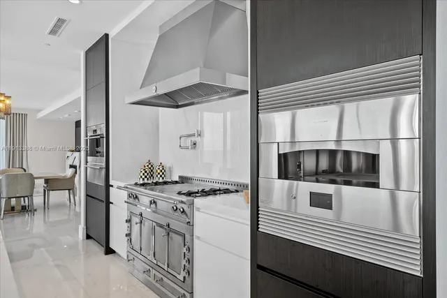 a kitchen with stainless steel appliances a stove a sink and a refrigerator