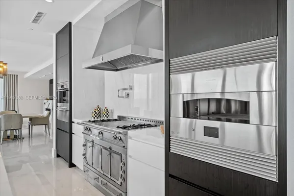 a kitchen with stainless steel appliances a stove a sink and a refrigerator