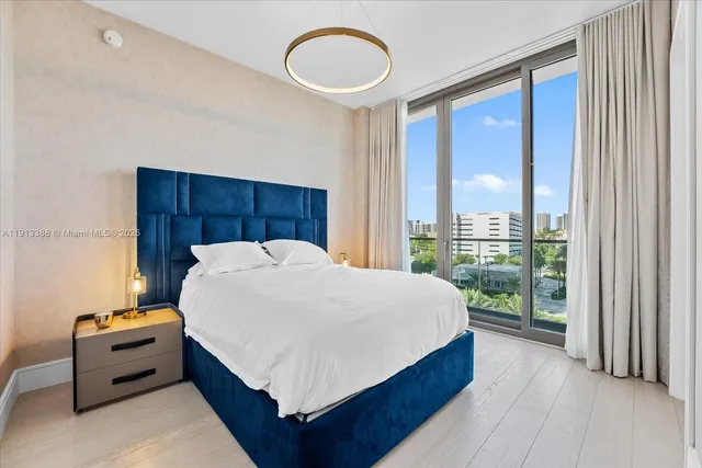 a bedroom with a bed and a flat tv screen on dresser