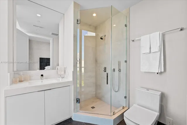 a bathroom with a granite countertop sink toilet and shower