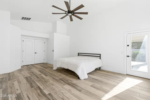 a bedroom with a bed and a ceiling fan