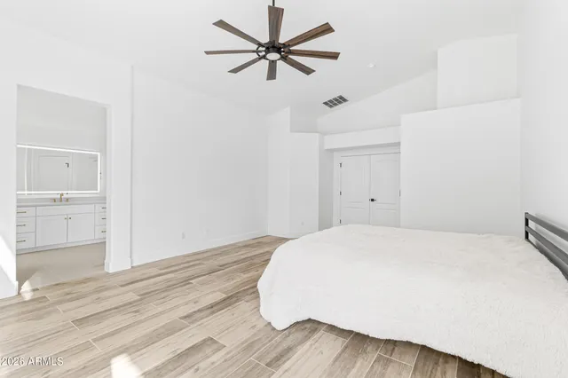 a bedroom with a bed and a ceiling fan