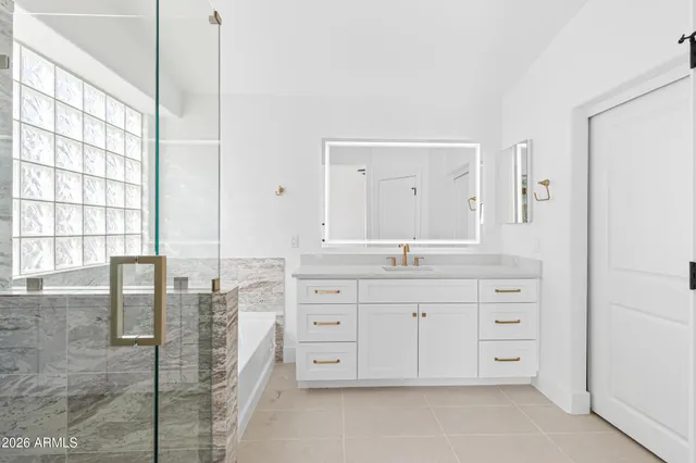 a spacious bathroom with a granite countertop sink a mirror and a shower