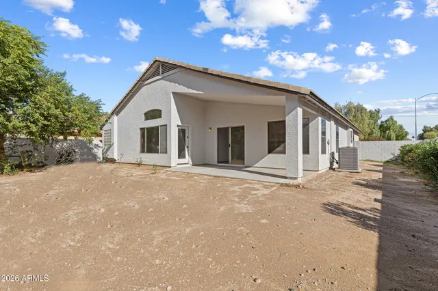 a view of a house with a big yard and large tree