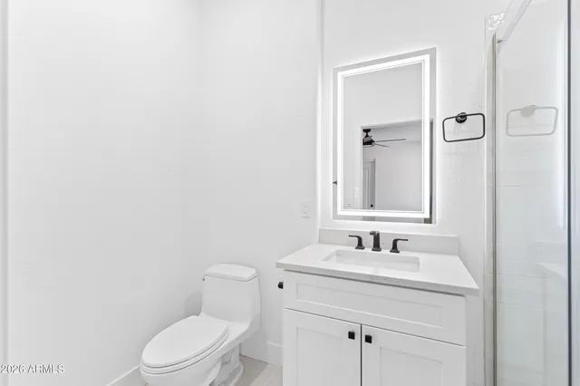 a bathroom with a toilet sink vanity and mirror