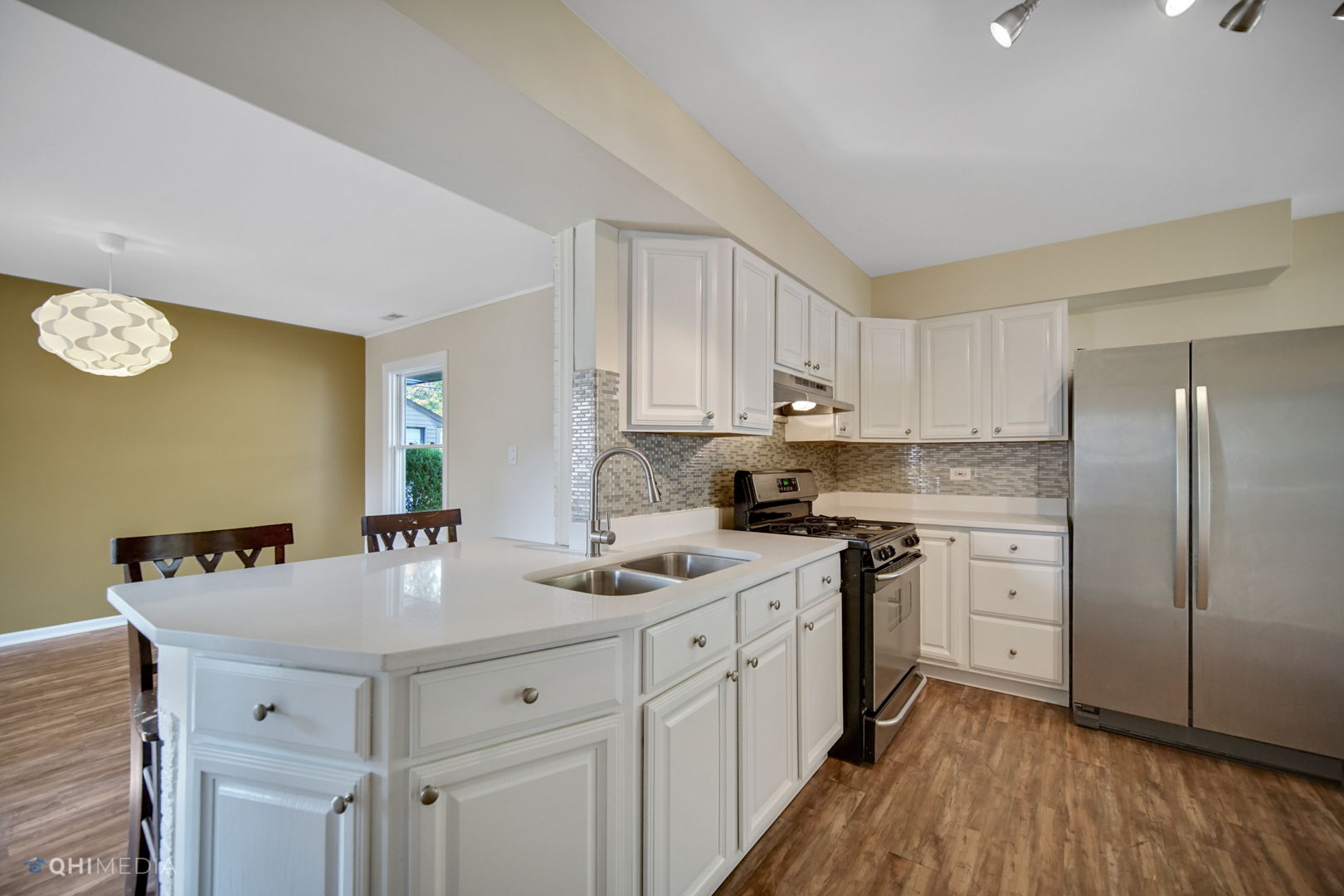 1217 183rd Street Homewood, IL 60430 - Photo 4 of 19 a kitchen with a sink dishwasher a stove a refrigerator and white cabinets with wooden floor