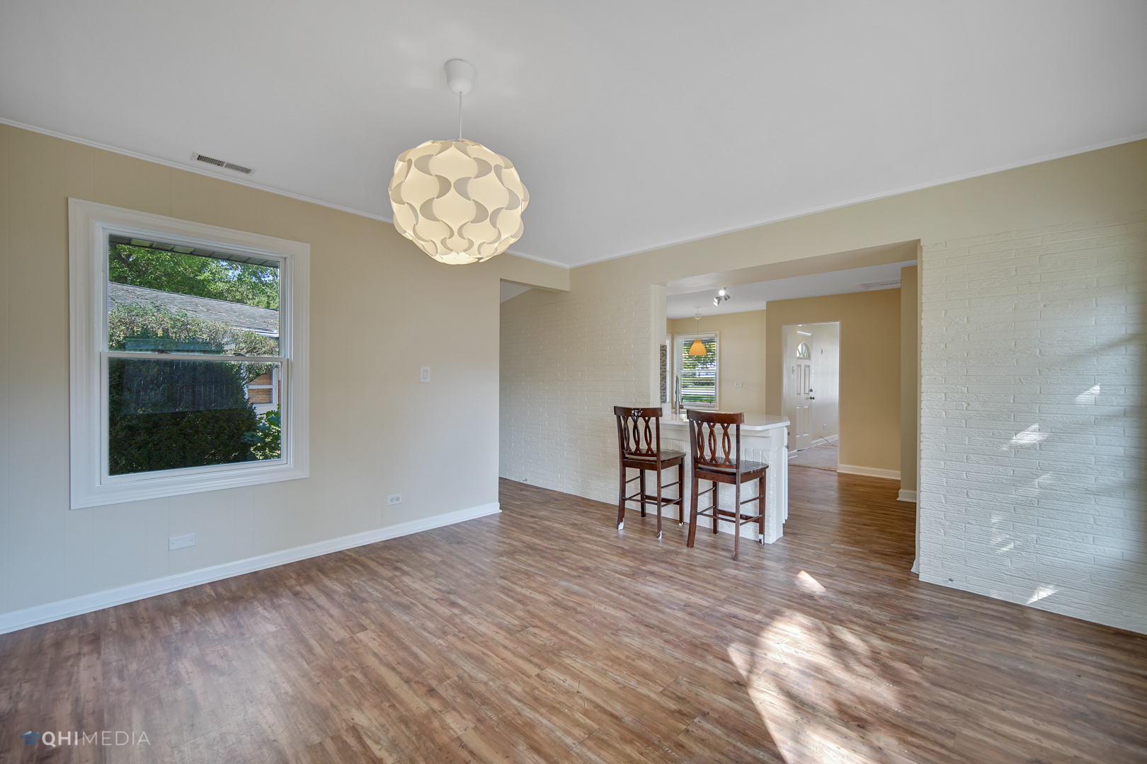 1217 183rd Street Homewood, IL 60430 - Photo 7 of 19 a view of a dining room and livingroom with furniture wooden floor a rug a chandelier and a window
