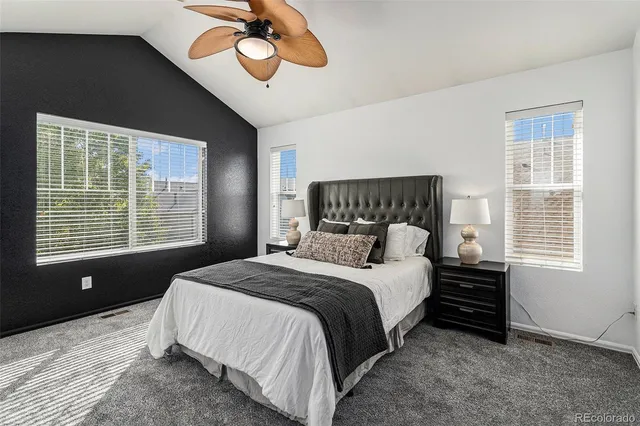 a bedroom with a bed lamp and a large window