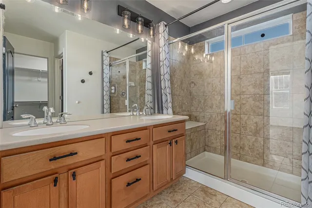 a bathroom with a double vanity sink mirror and shower