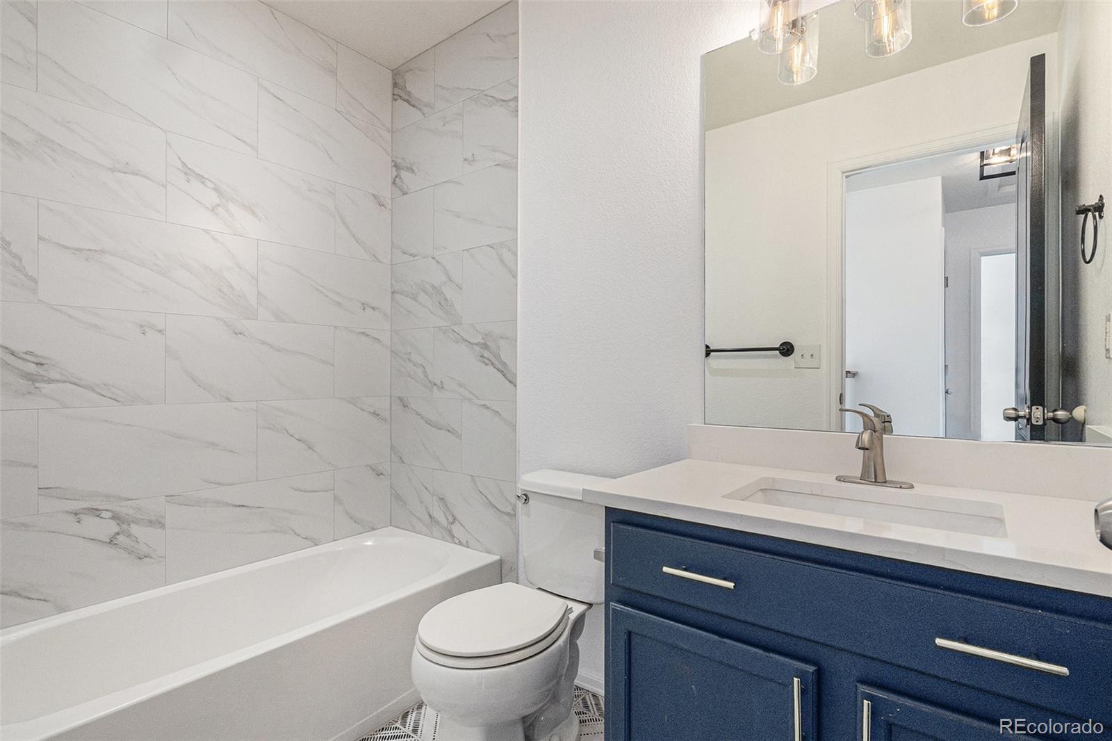 25970 East 3rd Avenue Aurora, CO 80018 - Photo 19 of 26 a bathroom with a sink a toilet and bathtub