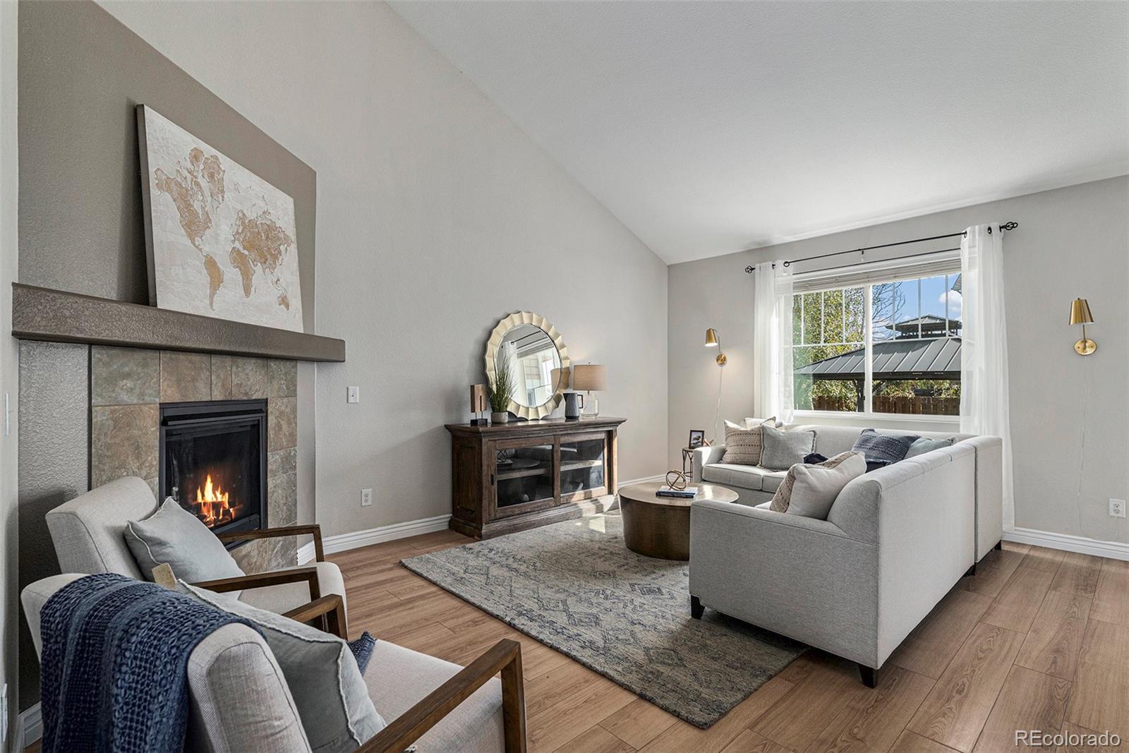 25970 East 3rd Avenue Aurora, CO 80018 - Photo 3 of 26 a living room with furniture and a fireplace