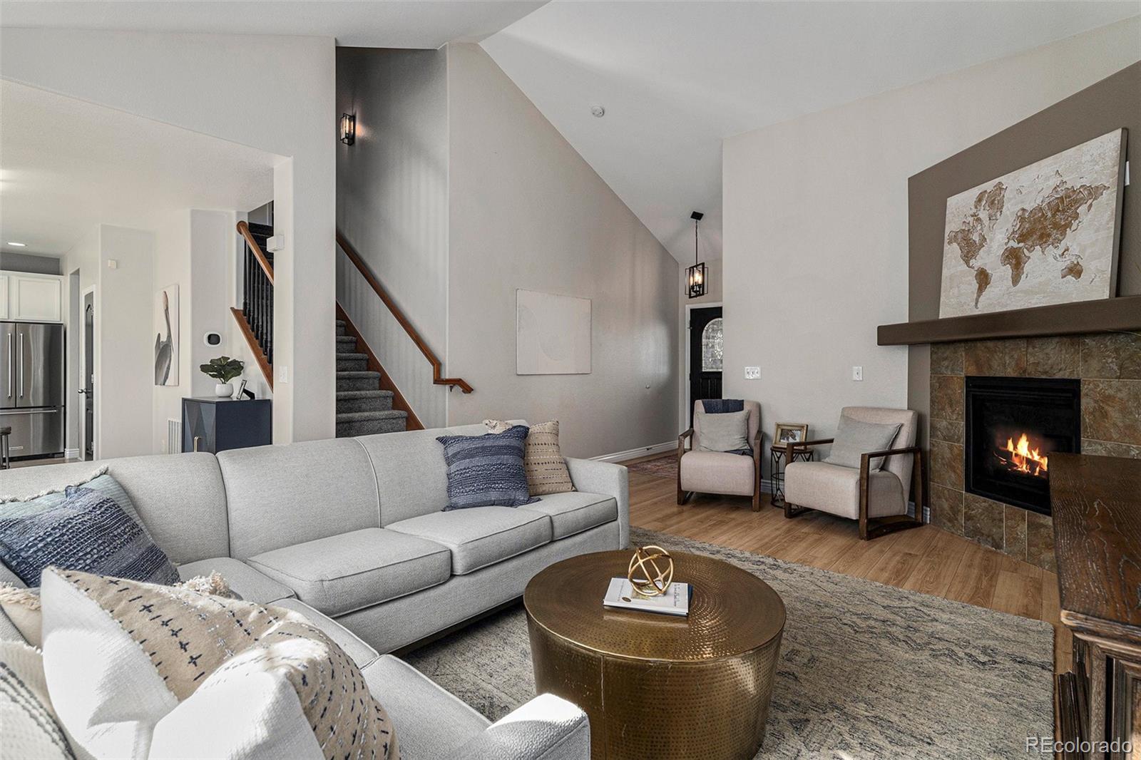 25970 East 3rd Avenue Aurora, CO 80018 - Photo 7 of 26 a living room with furniture and a fireplace