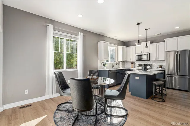 a view of a dining room with furniture a kitchen and chandelier
