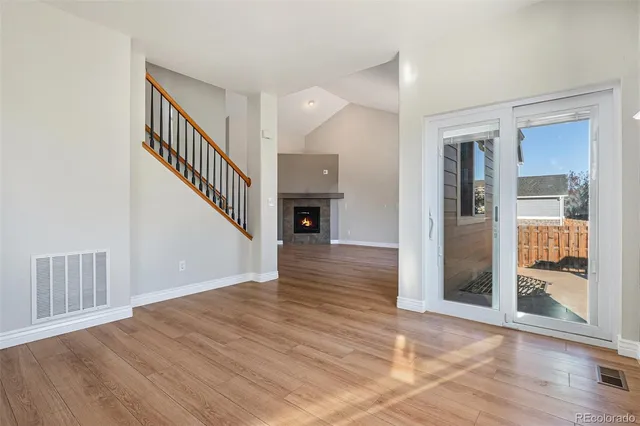 a view of a hallway with wooden floor and entryway