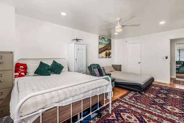 a bedroom with a bed and wooden floor
