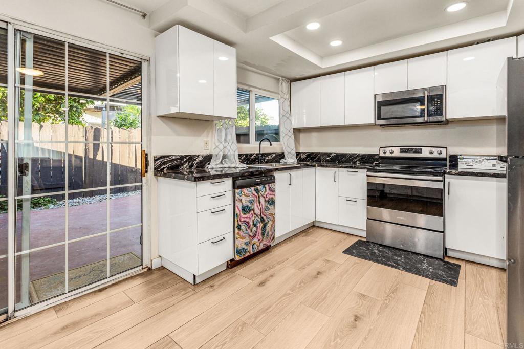 3446 Los Mochis Way Oceanside, CA 92056 - Photo 8 of 17 a kitchen with stainless steel appliances granite countertop a stove a sink and a microwave