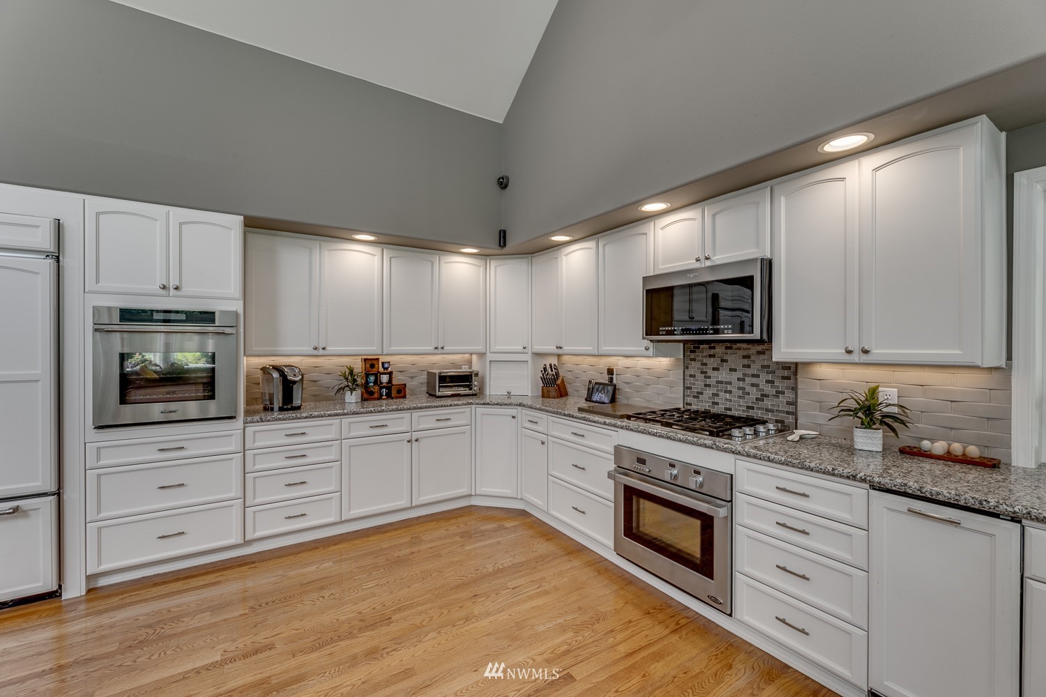 13819 3rd Drive Southeast Everett, WA 98208 - Photo 12 of 39 a large kitchen with stainless steel appliances granite countertop a stove top oven a sink dishwasher and white cabinets with wooden floor