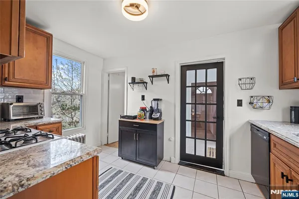 a kitchen with granite countertop a sink stove and cabinets