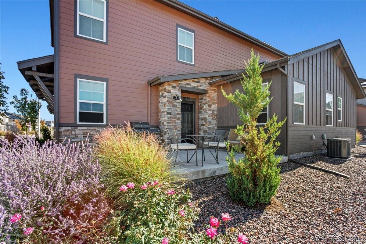a front view of house and yard with beautiful flowers