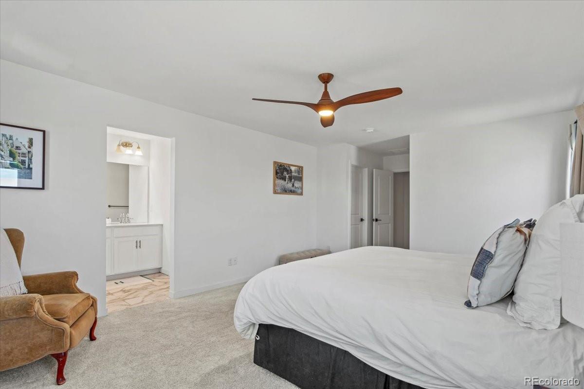 9790 Mount Kataka Point Littleton, CO 80125 - Photo 16 of 32 a bedroom with a bed and a chandelier