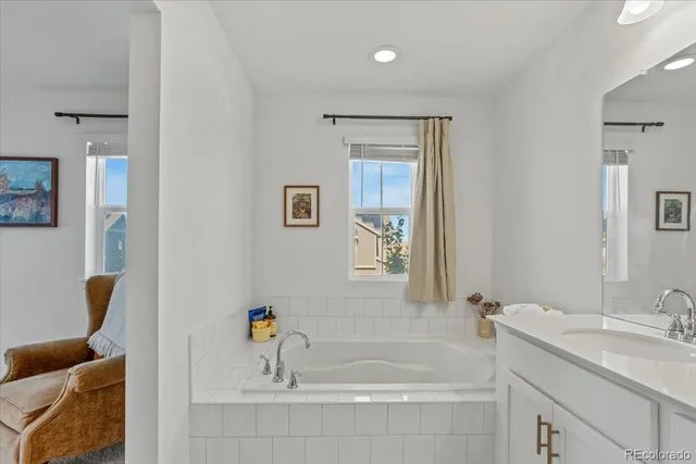 a bathroom with a tub sink and mirror