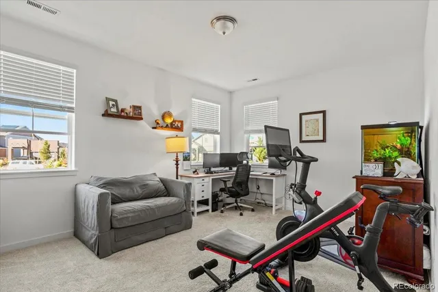 a living room with furniture gym equipment and a window