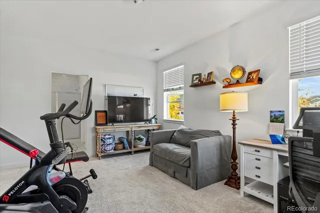 a living room with furniture a flat screen tv and a window