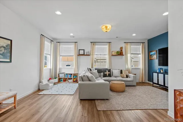 a living room with furniture and a wooden floor
