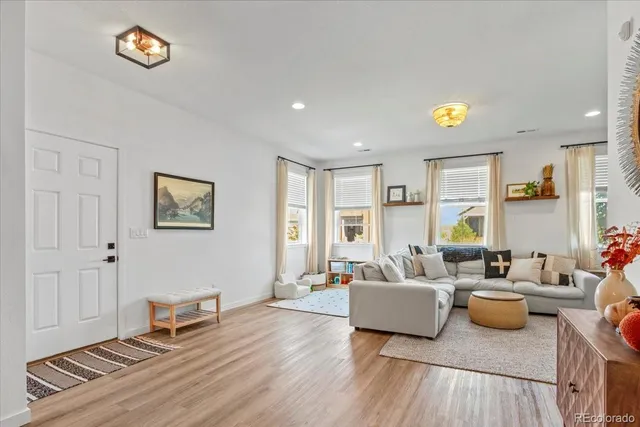a living room with furniture and a wooden floor