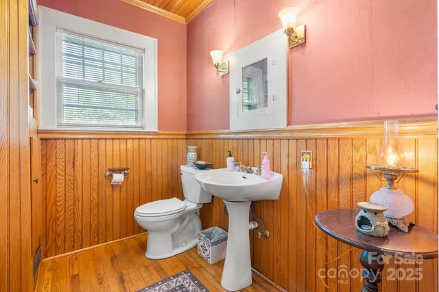 a view of a livingroom with wooden floor and a hallway