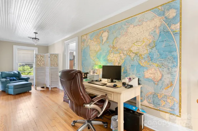 a bedroom with a bed a flat screen tv and a large window