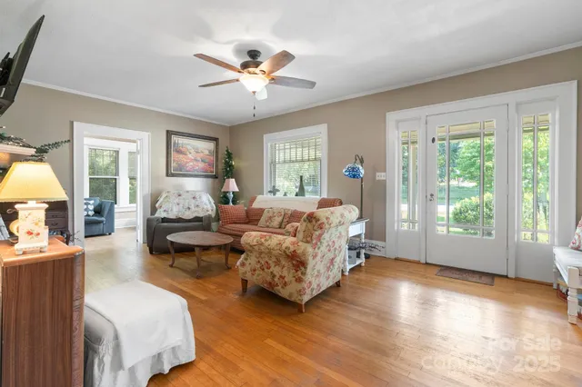 a spacious bedroom with a bed couches chair and a large window