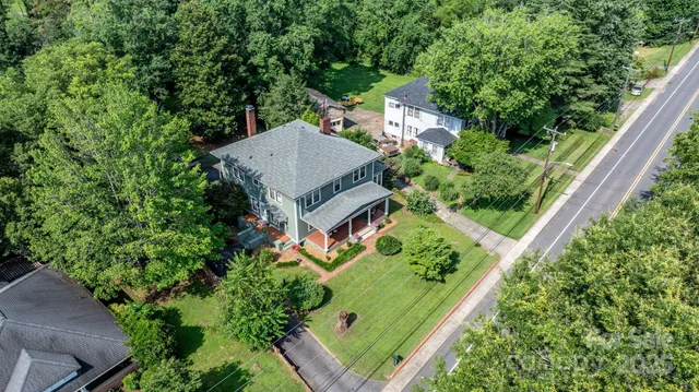 an aerial view of a house with a yard and large trees
