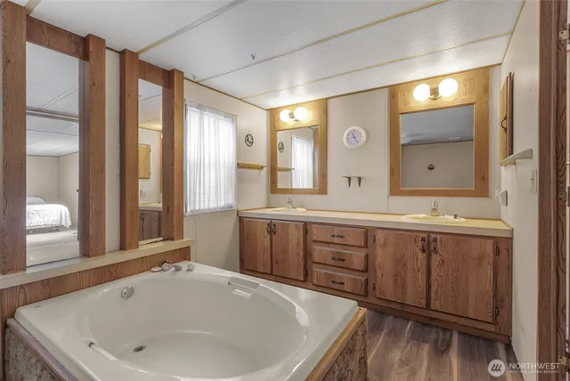 a bathroom with a tub sink and mirror